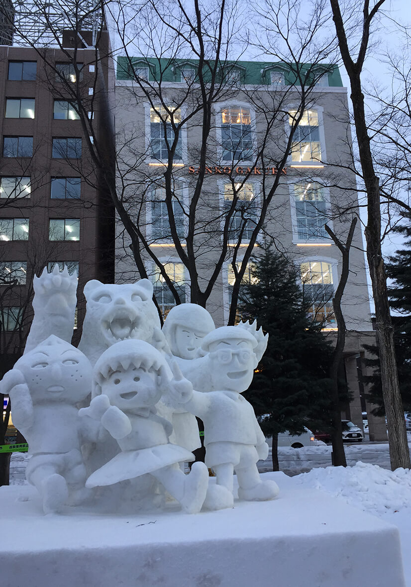 雪まつりの雪像たちに暖かい光を投げ掛ける（撮影  筆者による）